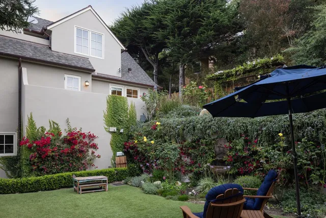a view of a chair and table in backyard of the house