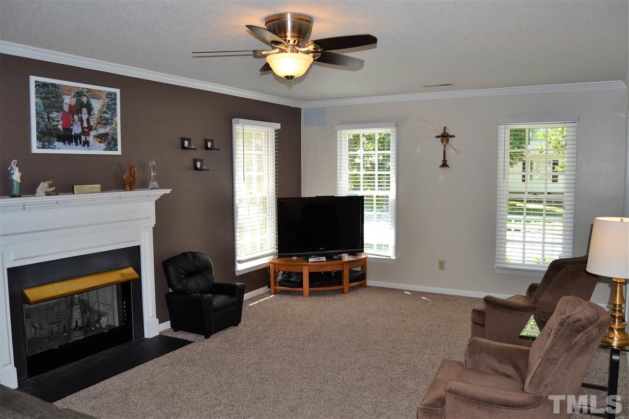 3537 Dechart Lane Raleigh, NC 27616 - Photo 6 of 21 a living room with furniture a fireplace and a flat screen tv