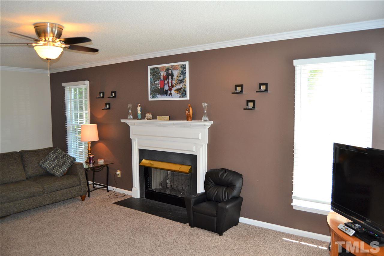 3537 Dechart Lane Raleigh, NC 27616 - Photo 7 of 21 a living room with furniture a flat screen tv and a fireplace