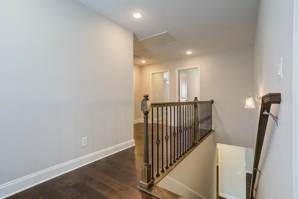 a view of a hallway with wooden floor and stairs