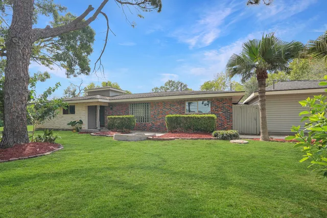 a kitchen with stainless steel appliances granite countertop a stove a sink and a dining table with chairs