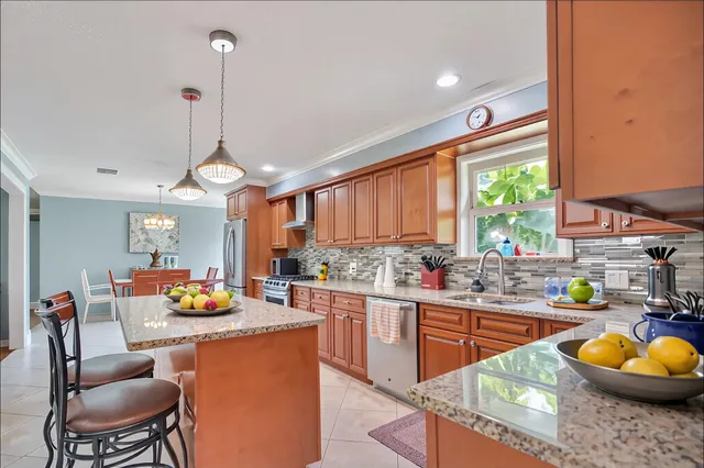 a kitchen with stainless steel appliances granite countertop sink stove and wooden cabinets
