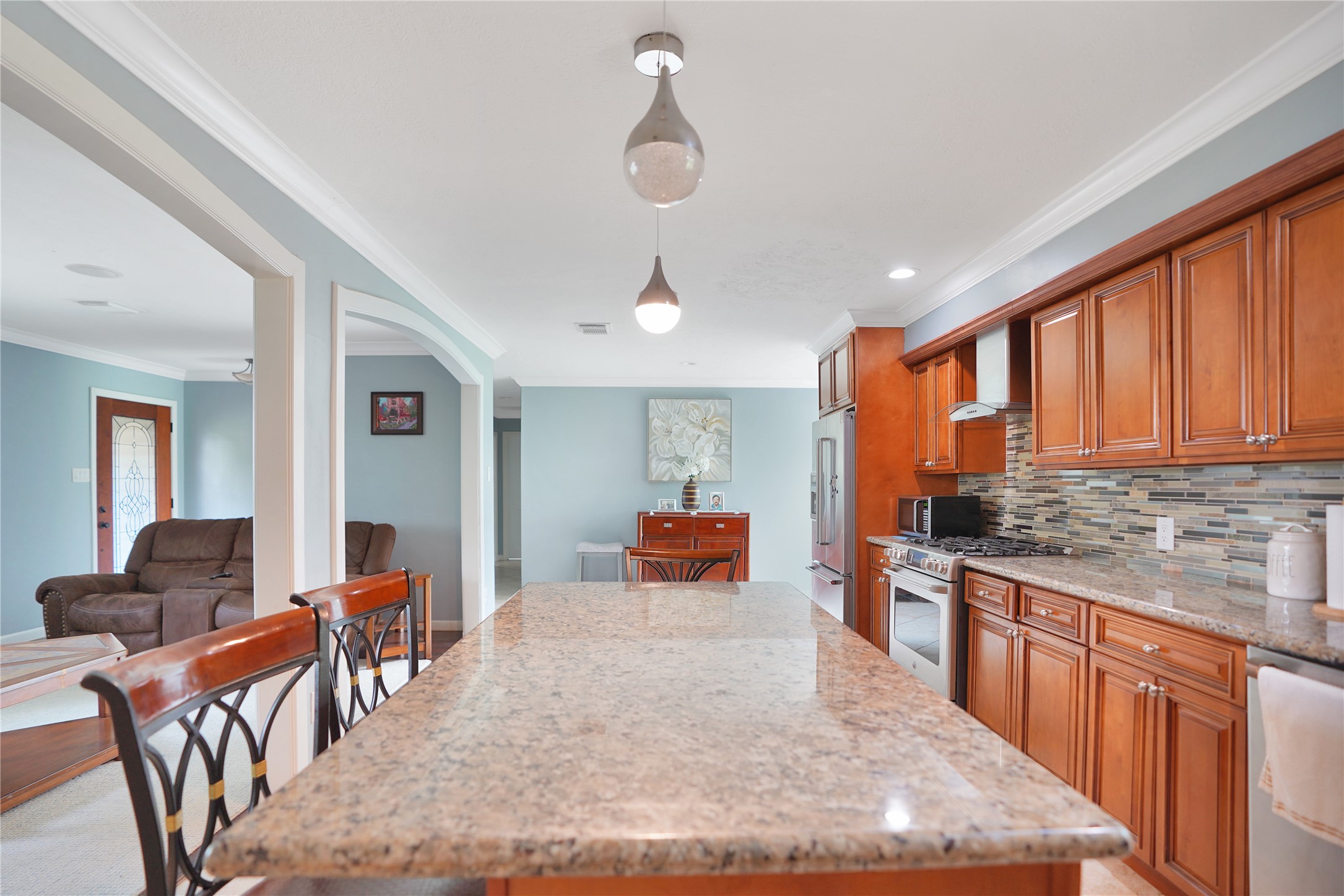 4920 Almeda Genoa Road Houston, TX 77048 - Photo 7 of 29 a kitchen with stainless steel appliances granite countertop sink stove and wooden cabinets