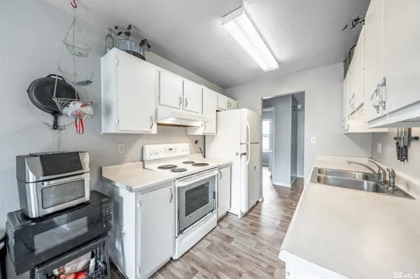 a kitchen with kitchen island granite countertop a sink cabinets stainless steel appliances and a counter top space