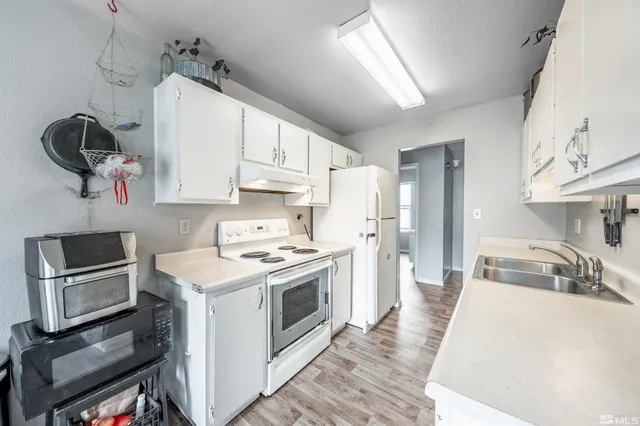 a kitchen with kitchen island granite countertop a sink cabinets stainless steel appliances and a counter top space