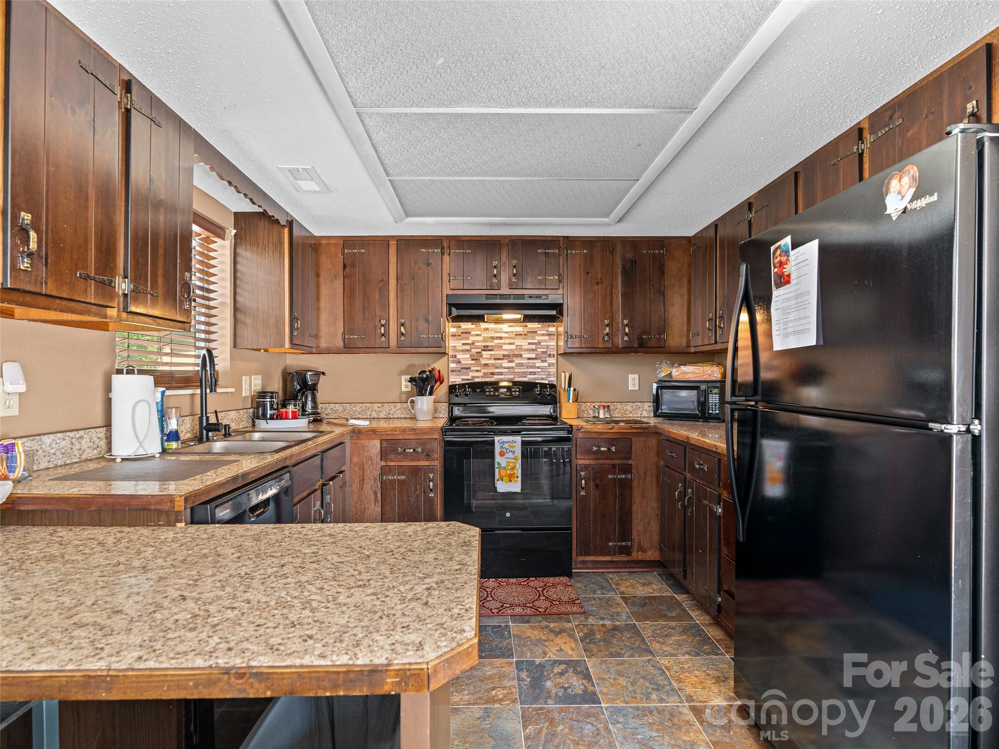 174 Pleasant Ridge Drive Maggie Valley, NC 28751 - Photo 16 of 45 a kitchen with stainless steel appliances granite countertop a stove refrigerator and sink