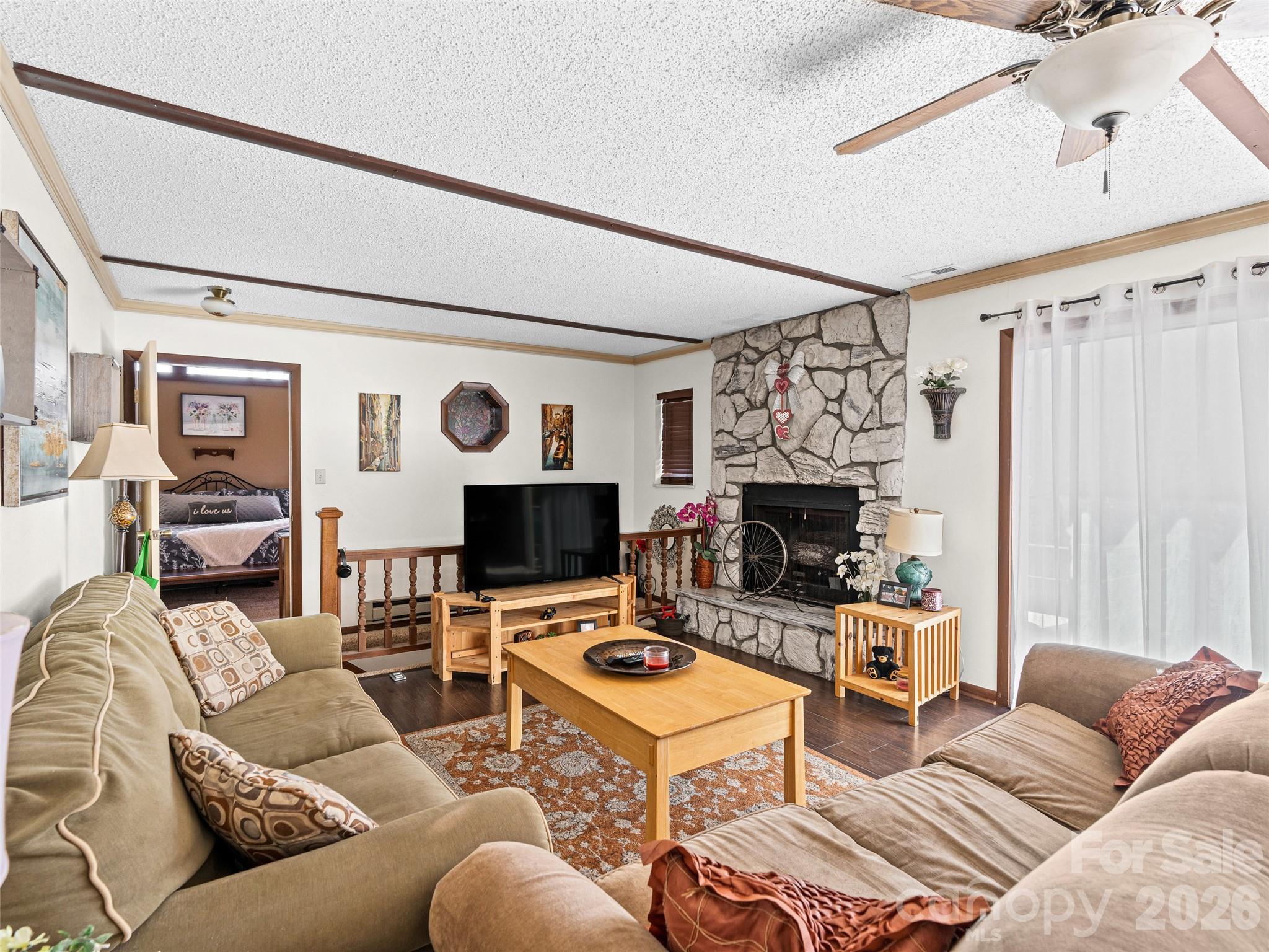 174 Pleasant Ridge Drive Maggie Valley, NC 28751 - Photo 5 of 45 a living room with furniture a fireplace and a flat screen tv