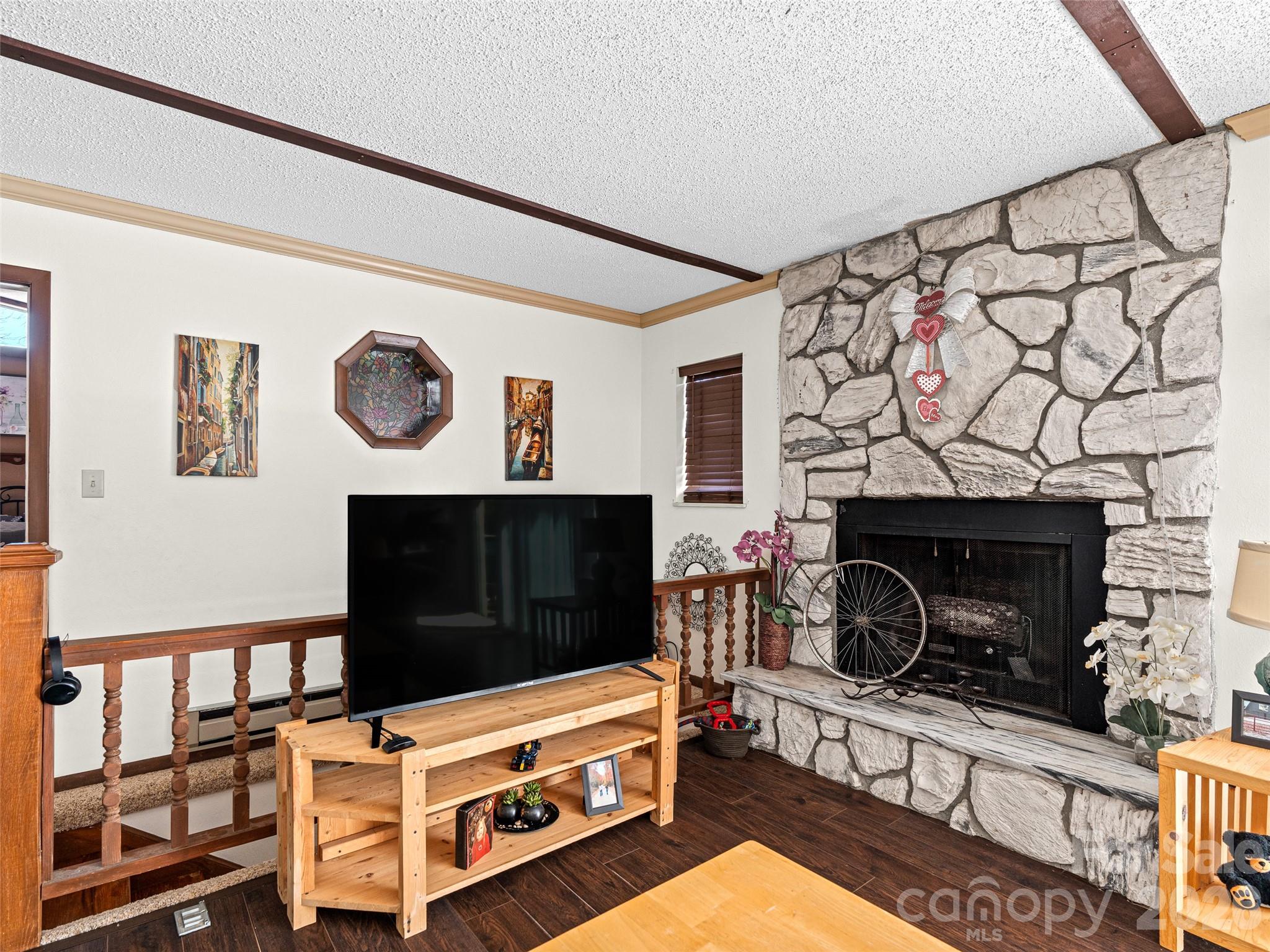 174 Pleasant Ridge Drive Maggie Valley, NC 28751 - Photo 6 of 45 a living room with a fireplace and a wall painting