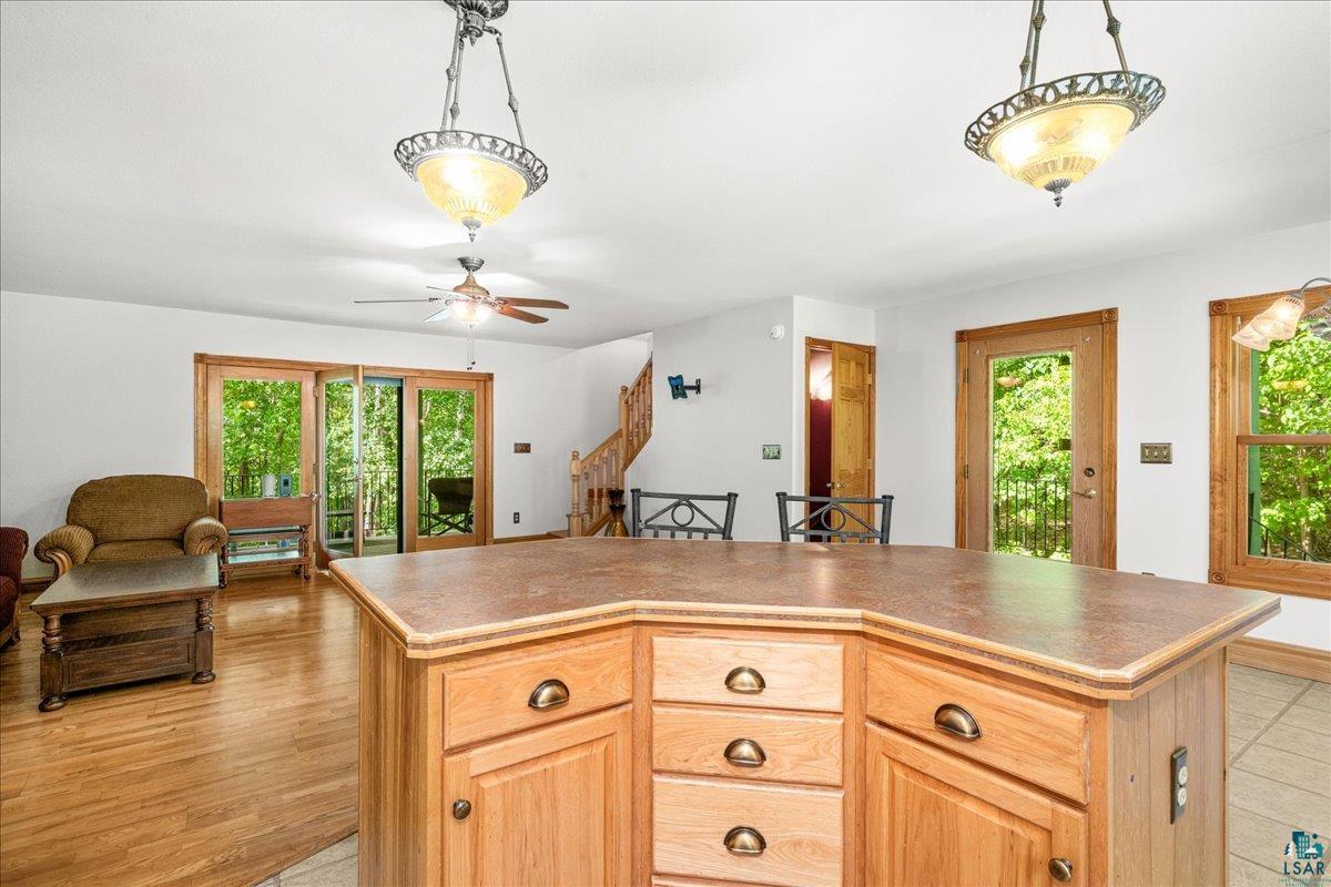 3799 South Lake Road Moose Lake, MN 55767 - Photo 12 of 35 Kitchen island featuring a laminate countertop, wood-finish cabinetry, and antique brass hardware