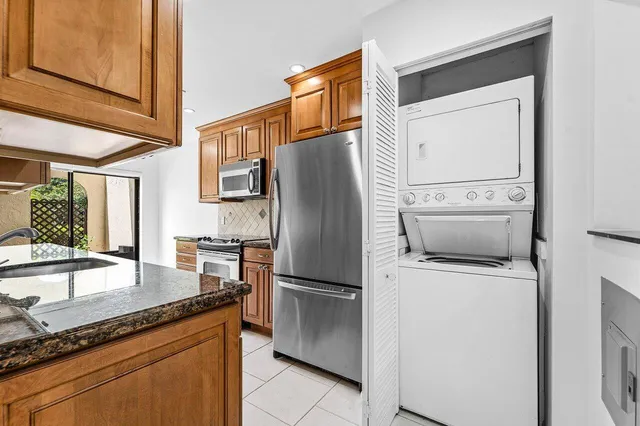 a kitchen with granite countertop a refrigerator and a sink