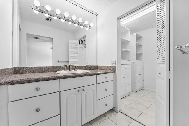 a bathroom with a granite countertop sink mirror and