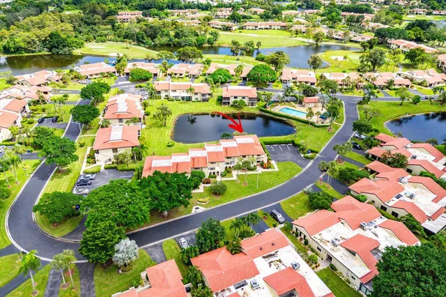 an aerial view of residential houses with yard and lake view