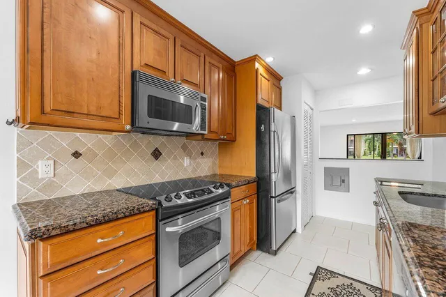 a kitchen with stainless steel appliances granite countertop a stove microwave and refrigerator