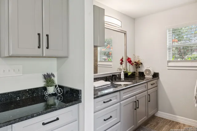 a kitchen with white cabinets and sink