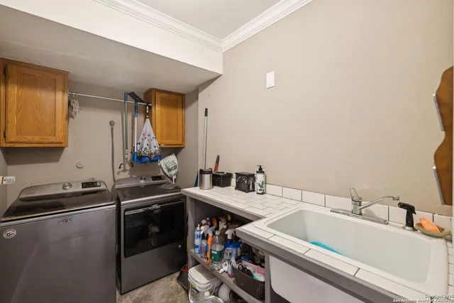a utility room with sink dryer and washer