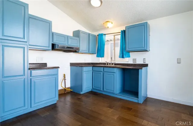 a kitchen with kitchen island wooden cabinets appliances and a sink