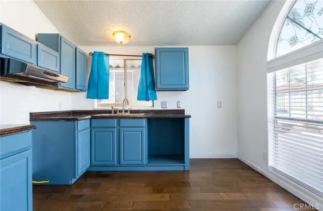 a kitchen with kitchen island granite countertop wooden cabinets a sink and a window