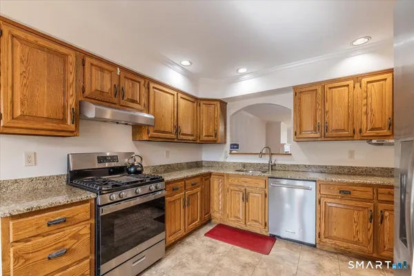 a kitchen with stainless steel appliances granite countertop a stove sink and cabinets