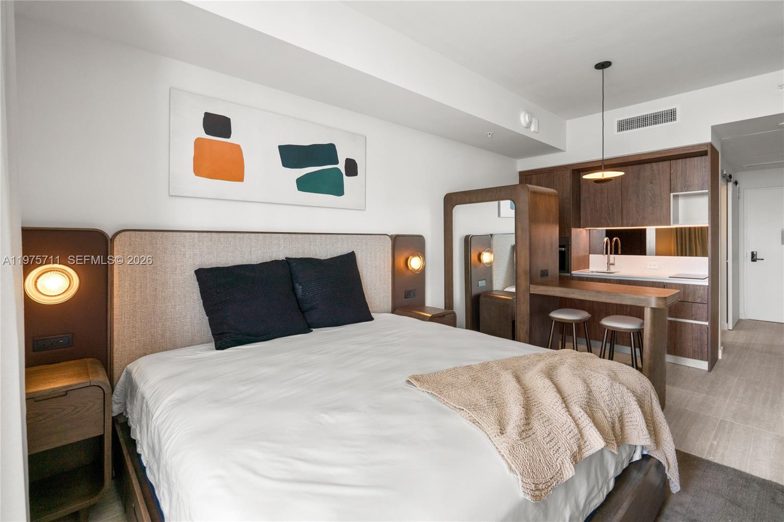 a large bedroom with a bed and wooden floor