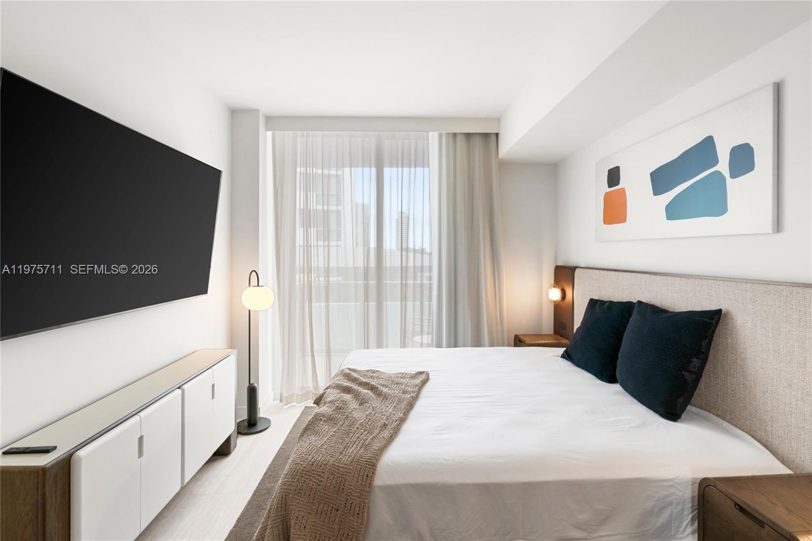 1611 Southwest 2nd Avenue, Unit 504 Miami, FL 33129 - Photo 3 of 17 a bedroom with a bed and a flat screen tv