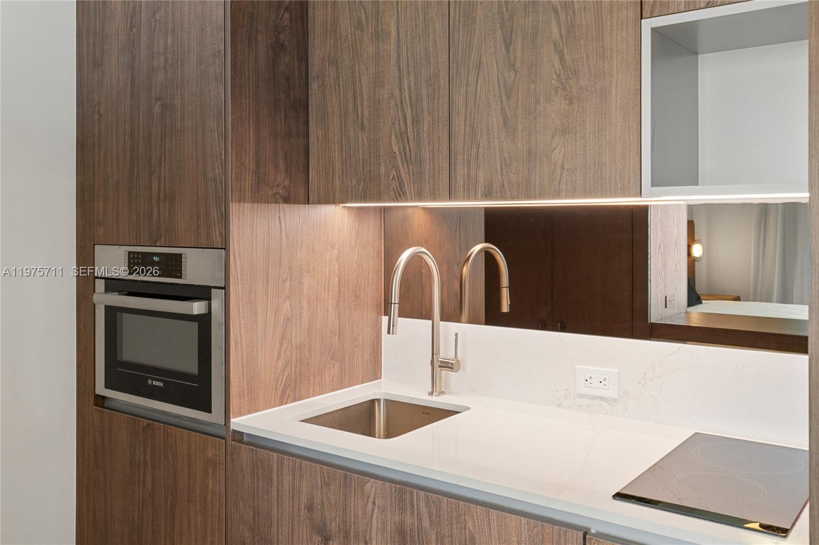 1611 Southwest 2nd Avenue, Unit 504 Miami, FL 33129 - Photo 5 of 17 a kitchen with a sink and a refrigerator