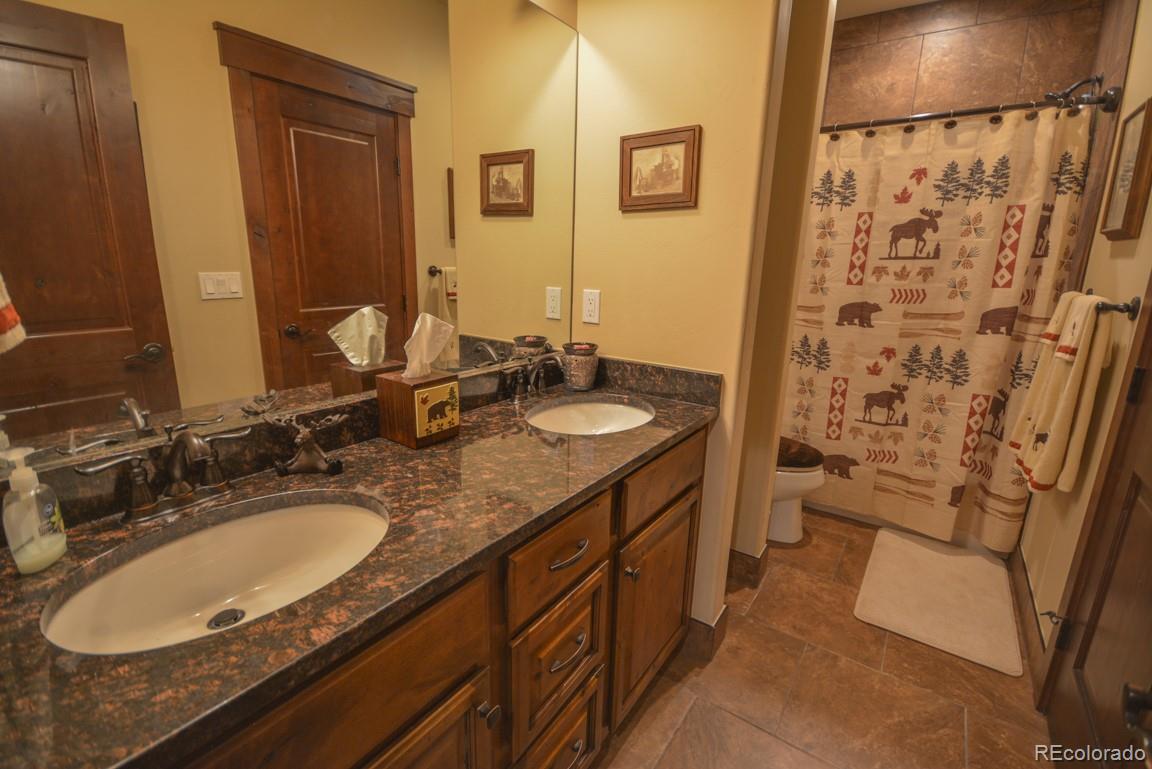 833 Independence Road Keystone, CO 80435 - Photo 32 of 38 a bathroom with a granite countertop sink and a mirror