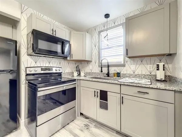 a kitchen with a sink stove and refrigerator