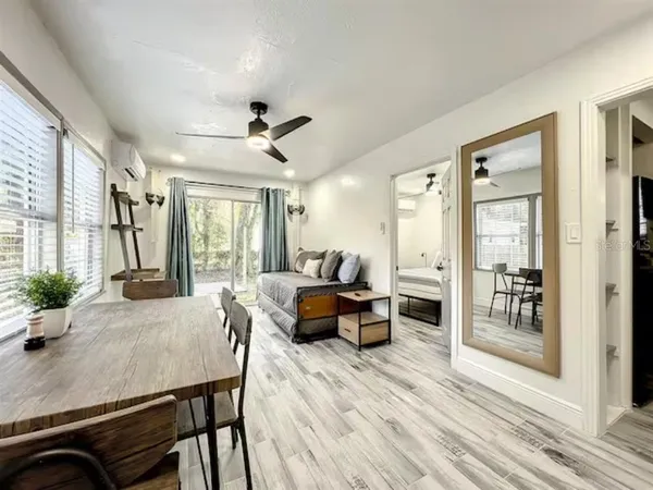 a view of a dining room with furniture a rug and wooden floor