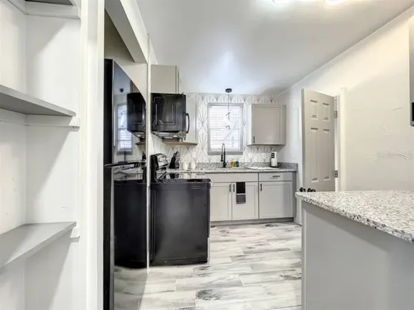 a kitchen with granite countertop cabinets stainless steel appliances and a sink