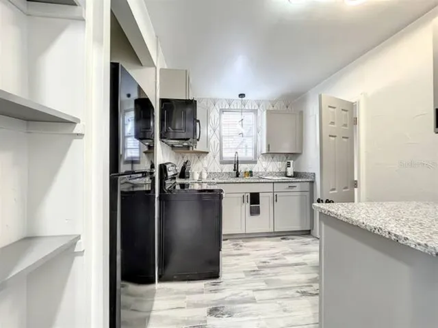 a kitchen with granite countertop cabinets stainless steel appliances and a sink