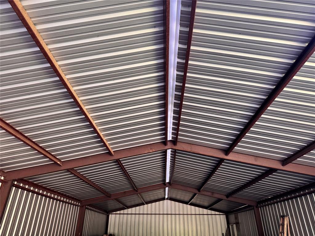 1002 6th Street Blanket, TX 76432 - Photo 6 of 16 Corrugated metal roof with exposed structural beams and integrated fluorescent lighting