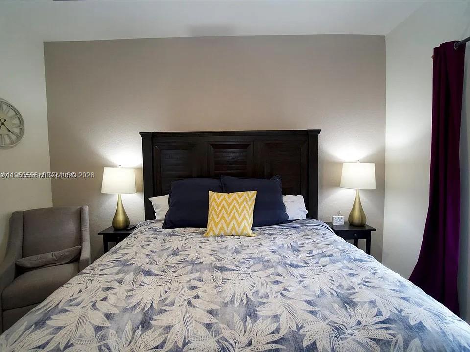 134 Northeast 23rd Terrace Homestead, FL 33033 - Photo 8 of 17 a bedroom with a bed and a lamp