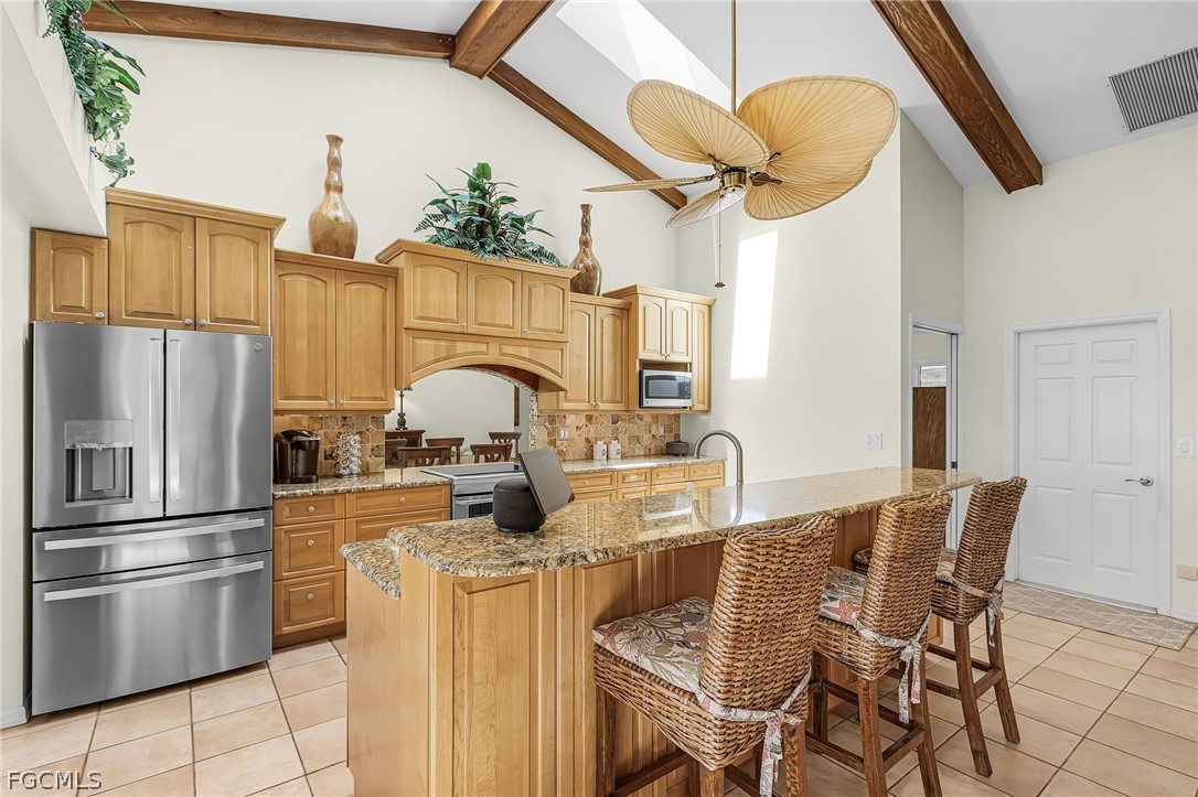 7747 Grande Pine Road Bokeelia, FL 33922 - Photo 12 of 45 a kitchen with dining table and stainless steel appliances