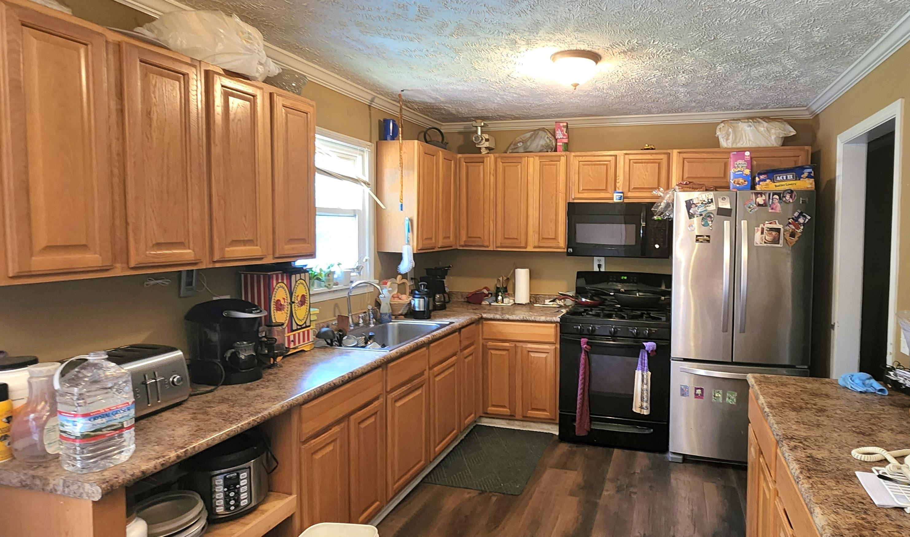 60 McAbee Road Jackson, TN 38301 - Photo 6 of 18 a kitchen with stainless steel appliances granite countertop a refrigerator a sink dishwasher a stove and white countertops with wooden floor