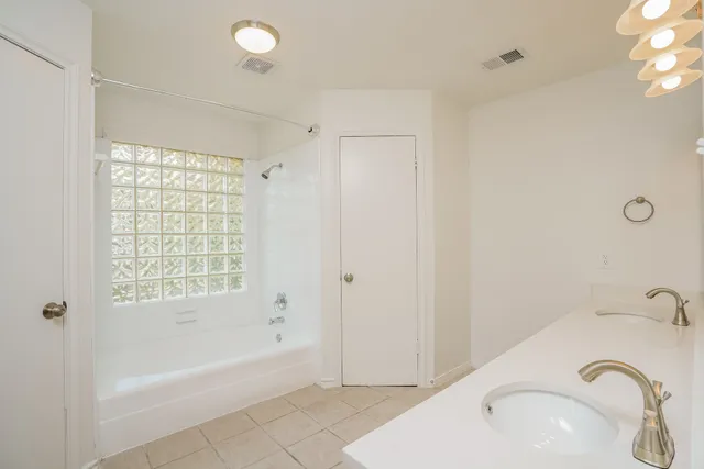 an empty room with a window and a fan