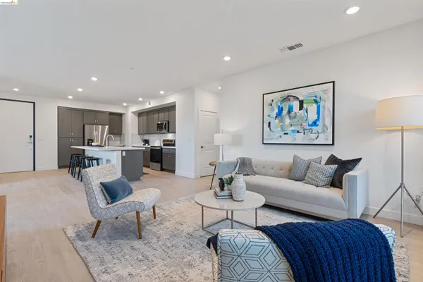 a living room with furniture kitchen view and a potted plant