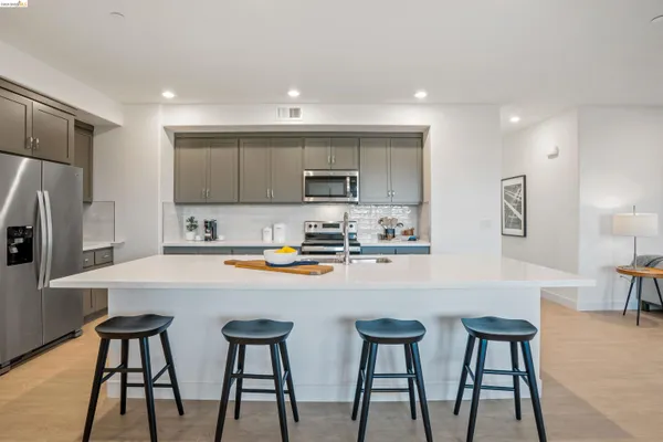 a kitchen with stainless steel appliances a refrigerator and a stove top oven with wooden floor