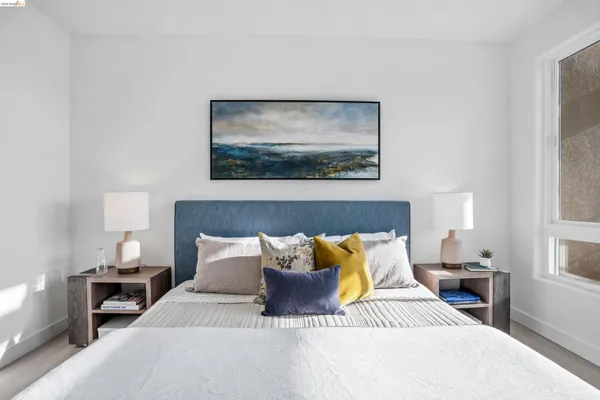 a bedroom with a bed and a painting on the wall