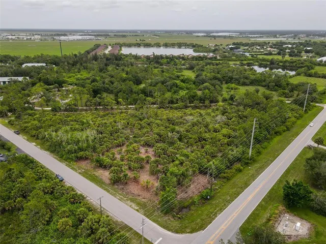 an aerial view of residential houses with outdoor space and trees