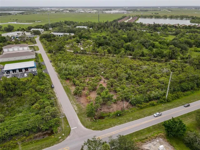 an aerial view of residential houses with outdoor space and trees