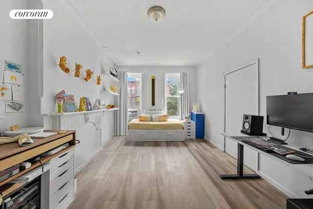 a bedroom with a bed and a flat tv screen on the dresser