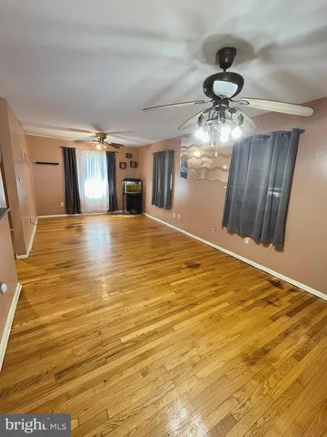 a view of empty room with window and ceiling fan