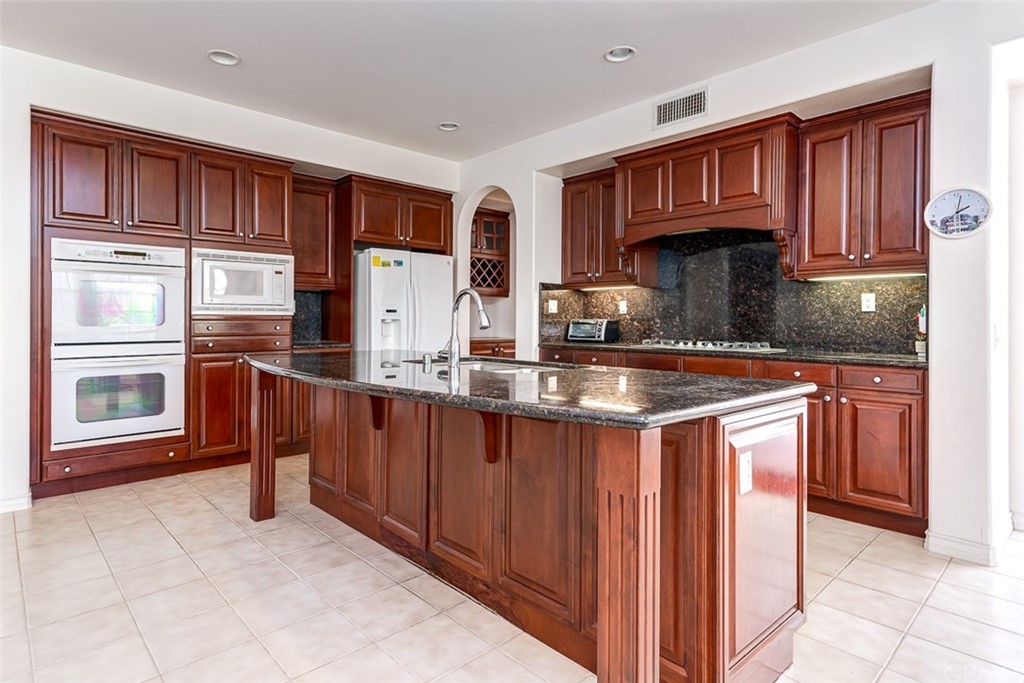 30 Paso Robles Irvine, CA 92602 - Photo 19 of 34 a kitchen with stainless steel appliances granite countertop a refrigerator and wooden cabinets