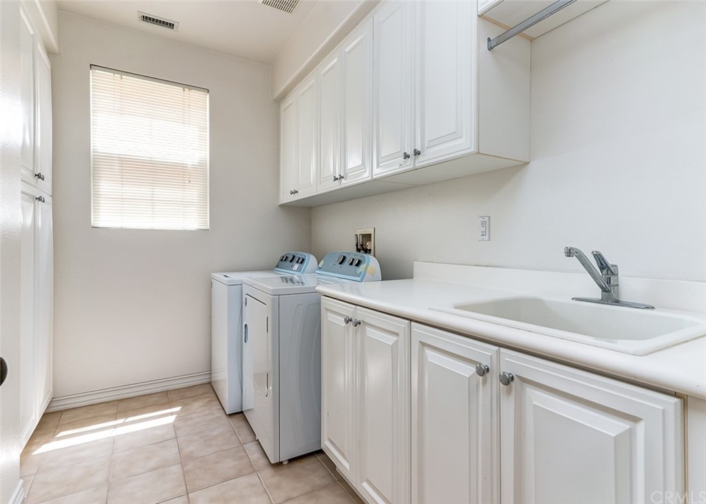 30 Paso Robles Irvine, CA 92602 - Photo 23 of 34 a utility room with cabinets washer and dryer