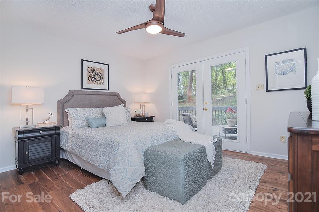 3499 Lake Shore Road South Denver, NC 28037 - Photo 22 of 35 a bedroom with a large bed and a chandelier