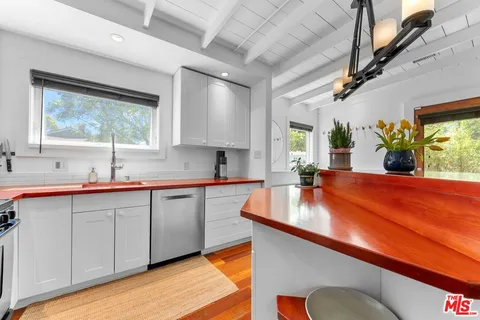 a kitchen with kitchen island granite countertop a sink cabinets and window