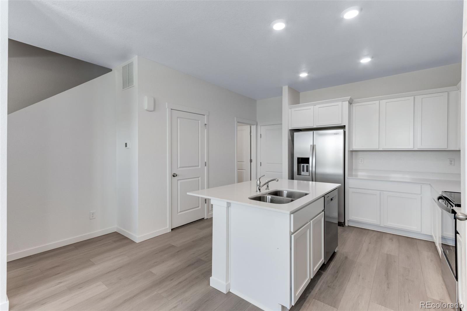 2344 Merlot Street Fort Lupton, CO 80621 - Photo 6 of 23 a kitchen that has stainless steel appliances granite countertop a sink stove and refrigerator