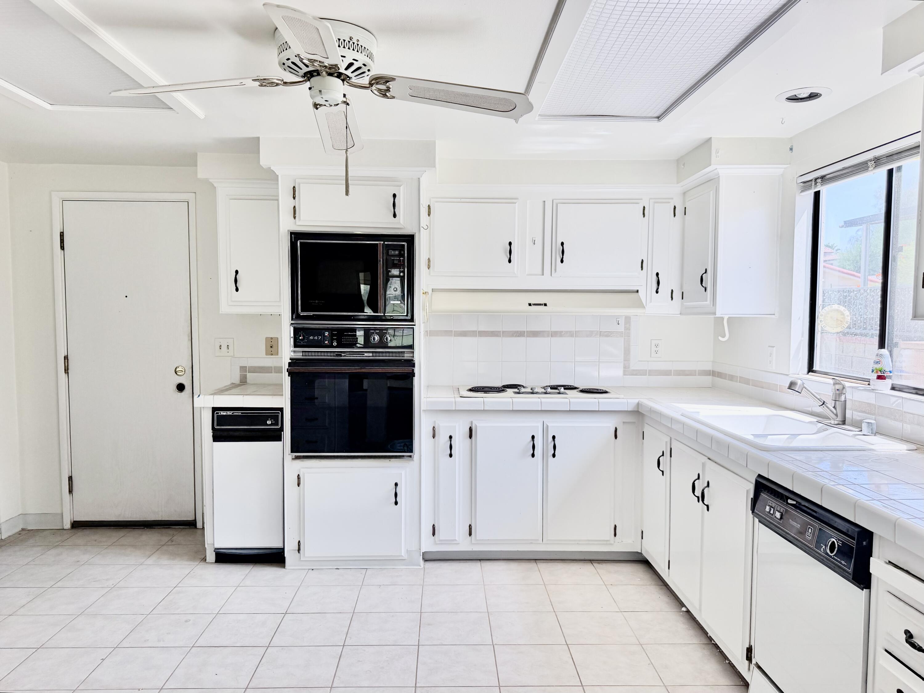 74361 Angel Camp Road Palm Desert, CA 92260 - Photo 4 of 12 a kitchen with granite countertop a sink stove and refrigerator