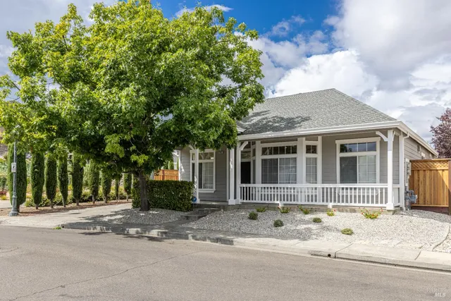 a front view of a house with a garden and plants