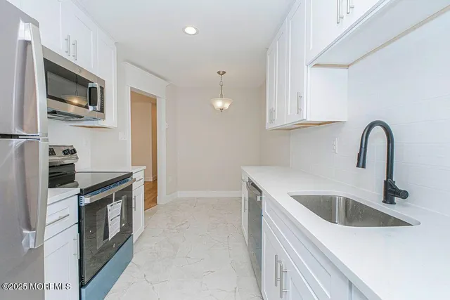 a kitchen with white cabinets sink and dishwasher